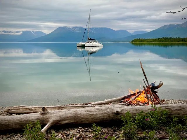 Odyssey at anchor with a shore fire nearby