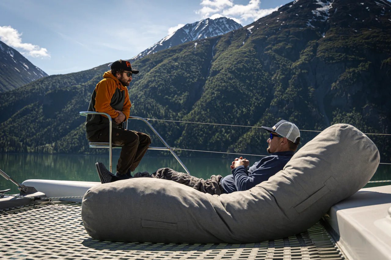 Guests relaxing on Odyssey’s deck with Lake Clark and the mountains behind them