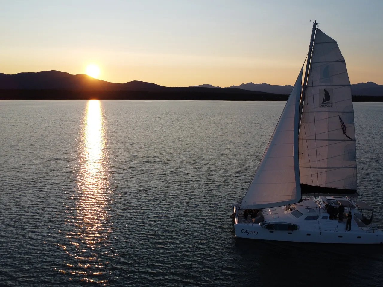 Odyssey sailing on Lake Clark as the sun sets behind the mountains